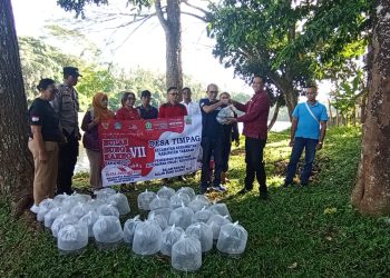 Bhabinkamtibmas Desa Timpag Ikuti Penebaran 10000 Benih Ikan Nila di Bendungan Telaga Tunjung